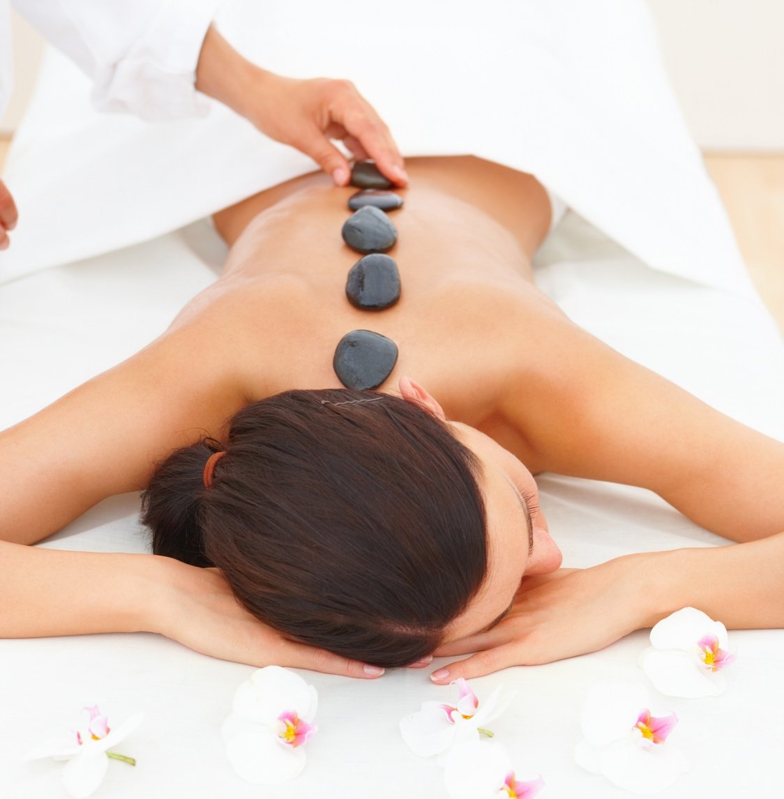 Woman receiving hotstone massage at spa